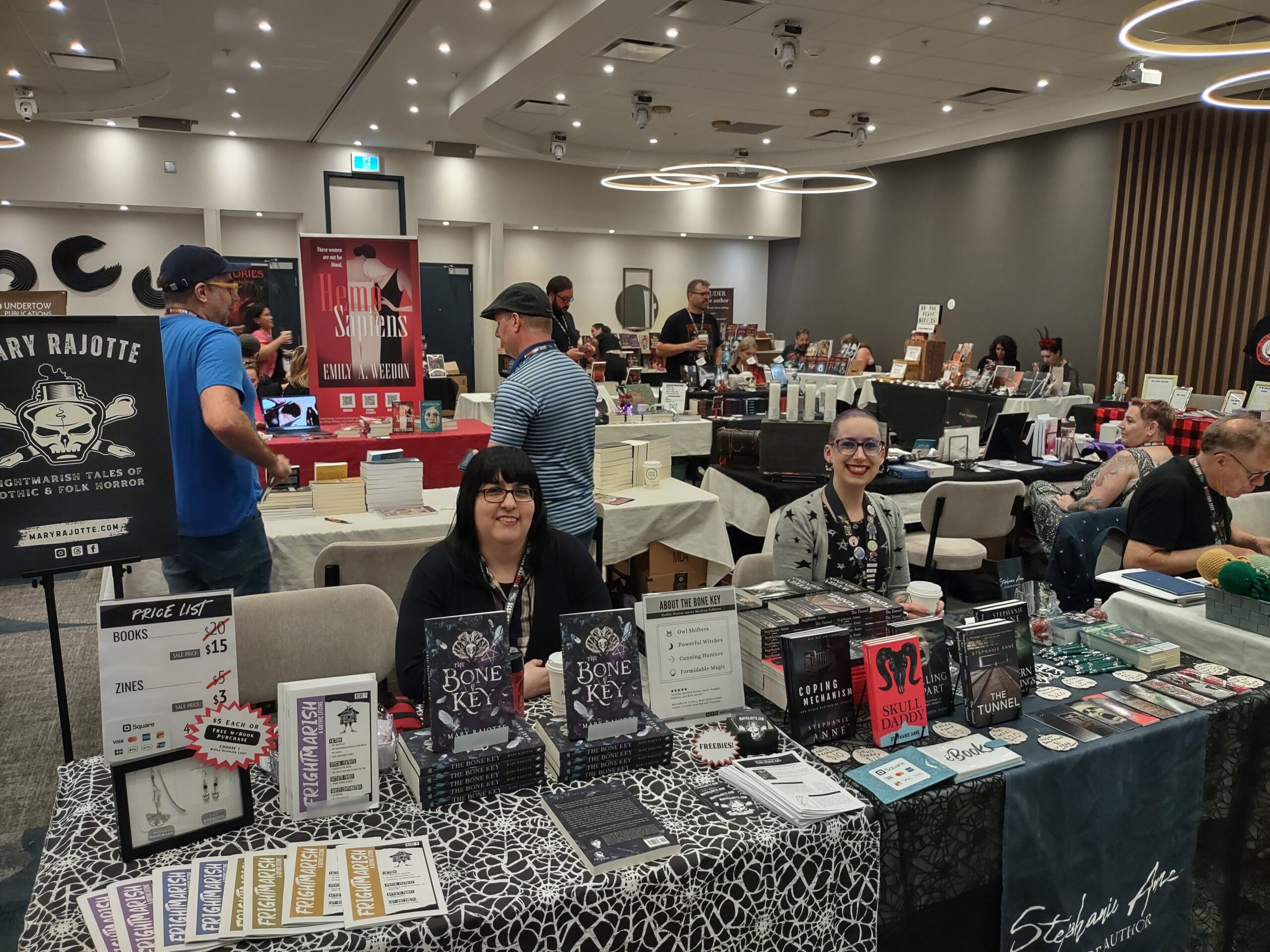 Authors Mary Rajotte and Stephanie Anne at their tables during dReadCon 2025