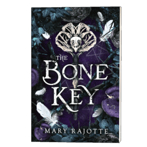 The Bone Key paperback cover with an owl skull atop a bone key, set against a forest floor with white feathers, purple mushrooms and iridescent teal branches