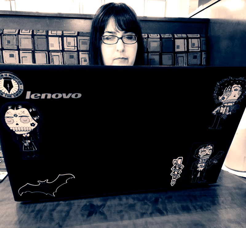 Author Mary Rajotte sitting behind her laptop typing